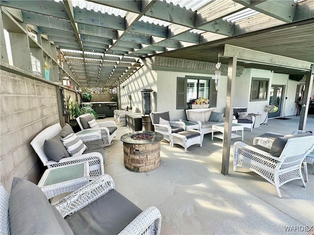 view of patio with a hot tub, fence, a pergola, and an outdoor living space with a fire pit