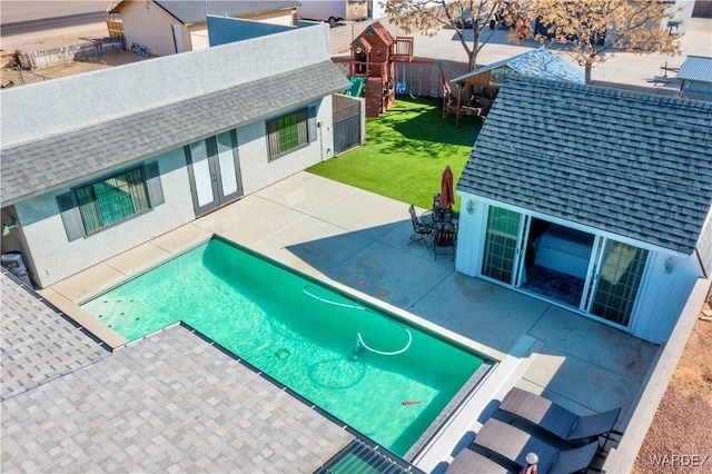 view of swimming pool featuring a playground, a yard, and a patio area