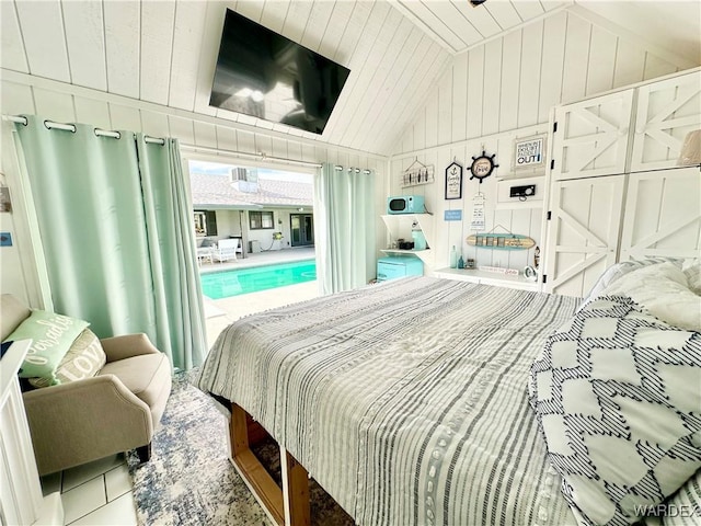 bedroom with access to exterior, lofted ceiling, and wooden walls