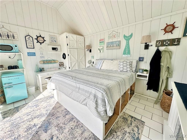 bedroom with light tile patterned floors, vaulted ceiling, and wood ceiling