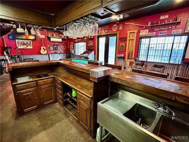 bar featuring a dry bar, concrete floors, and french doors