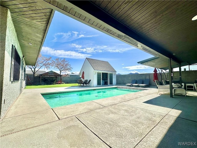 view of pool with a fenced in pool, a fenced backyard, an outdoor structure, a patio area, and an exterior structure