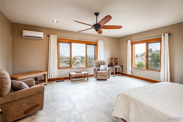 bedroom with a wall unit AC, baseboards, a ceiling fan, and recessed lighting