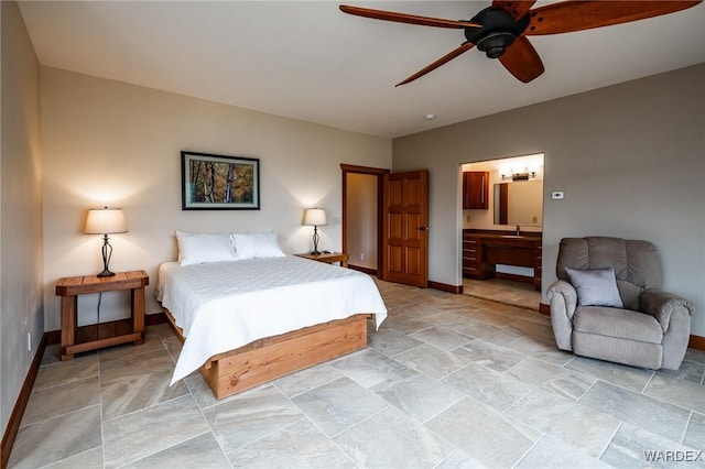 bedroom featuring stone finish flooring, a sink, connected bathroom, ceiling fan, and baseboards