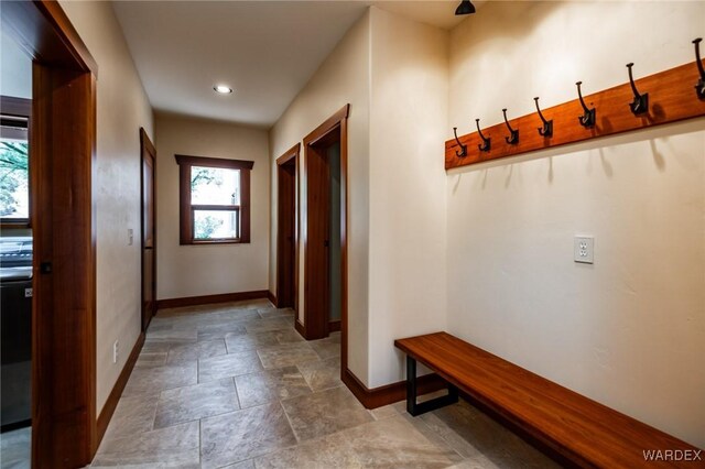 mudroom featuring stone finish floor and baseboards