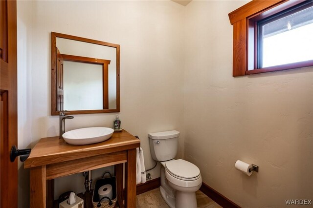 bathroom with vanity, toilet, and baseboards