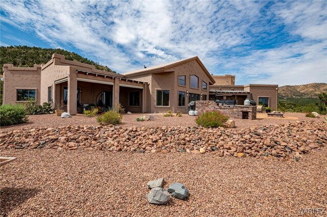 back of house featuring an outdoor kitchen and stucco siding