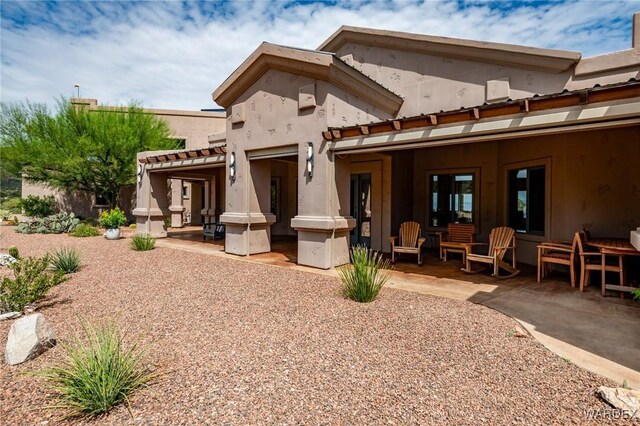 back of property featuring a patio and stucco siding