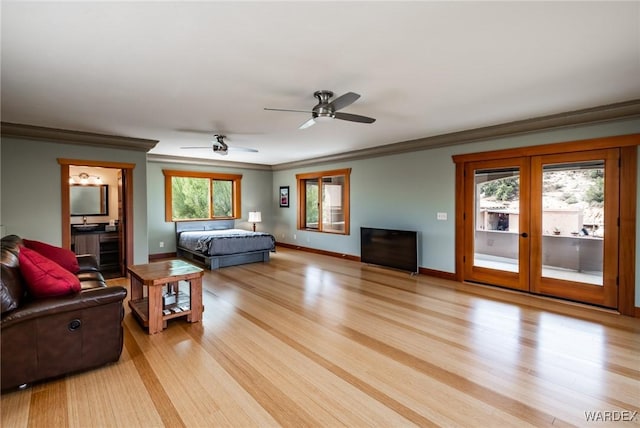 living room featuring a ceiling fan, baseboards, crown molding, and light wood finished floors