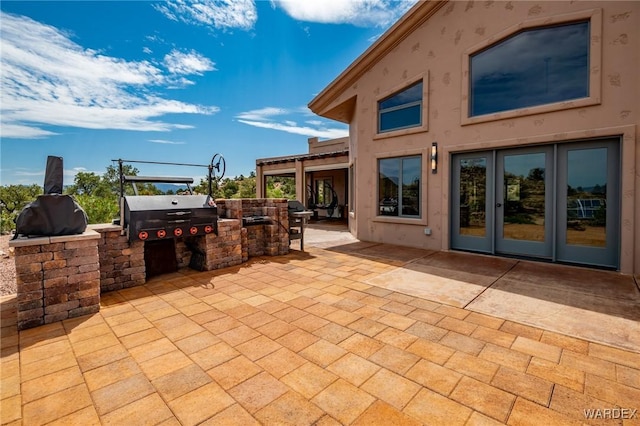 view of patio featuring exterior kitchen, french doors, and grilling area