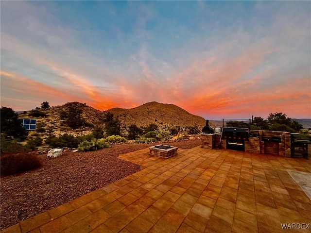 view of patio with a mountain view and a fire pit