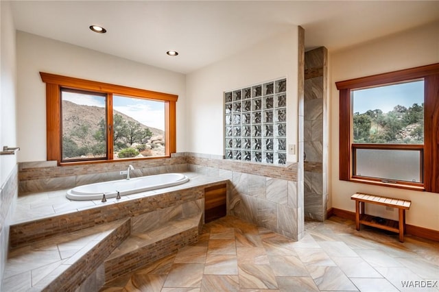 bathroom featuring a garden tub, a mountain view, and recessed lighting