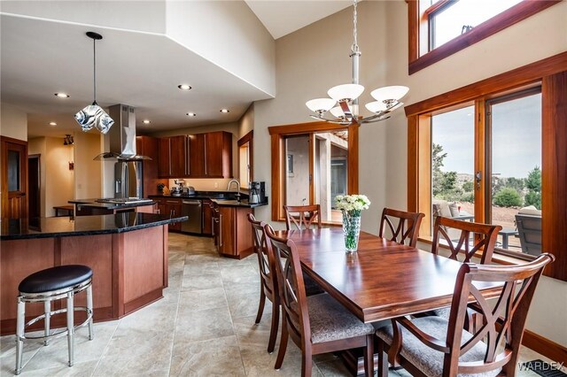 dining space with a high ceiling, recessed lighting, and an inviting chandelier