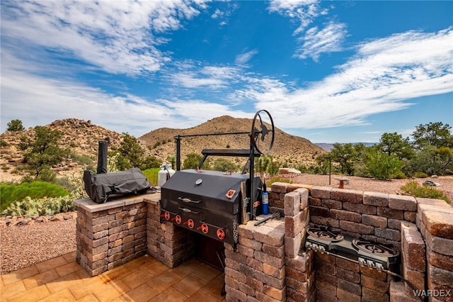 view of patio / terrace featuring a mountain view and exterior kitchen