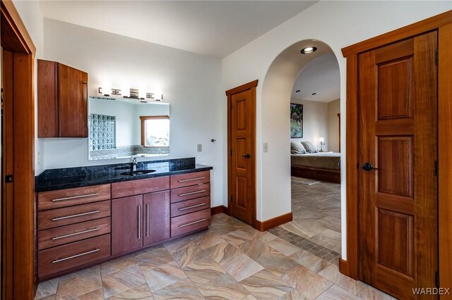 ensuite bathroom featuring ensuite bathroom, vanity, and baseboards