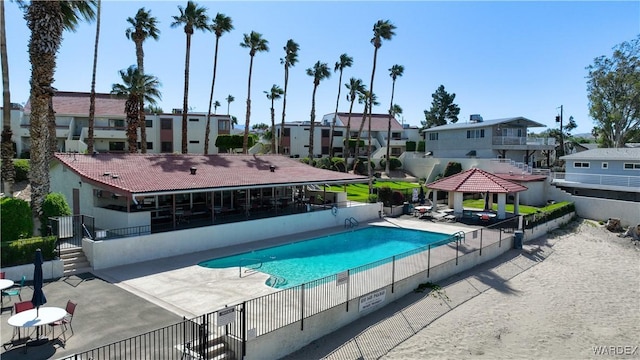 community pool with a gazebo, fence, a residential view, and a patio