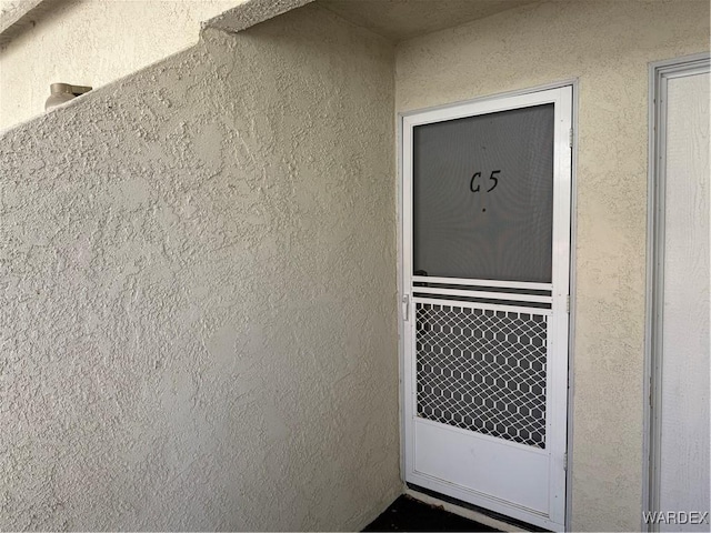 view of exterior entry with stucco siding