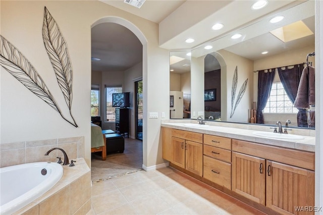 full bathroom with plenty of natural light, a sink, and ensuite bathroom