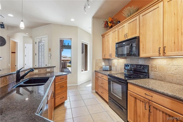 kitchen with dark stone counters, black appliances, a sink, and pendant lighting