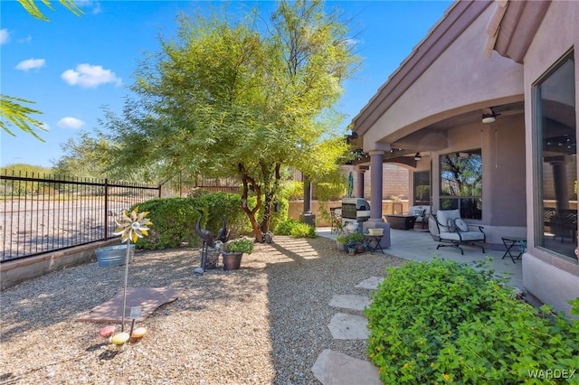 view of yard featuring ceiling fan, a fenced backyard, and a patio