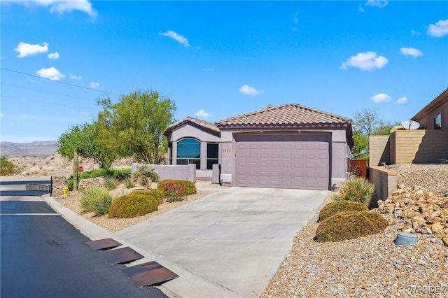 mediterranean / spanish home featuring stucco siding, concrete driveway, an attached garage, fence, and a tiled roof