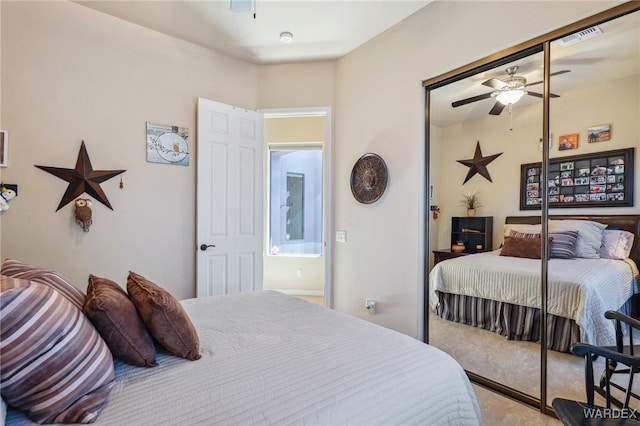 carpeted bedroom featuring a closet, visible vents, and a ceiling fan