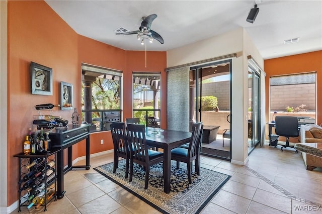 dining area with light tile patterned floors, a ceiling fan, visible vents, and baseboards