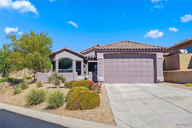 view of front facade with a garage, driveway, a tile roof, and stucco siding