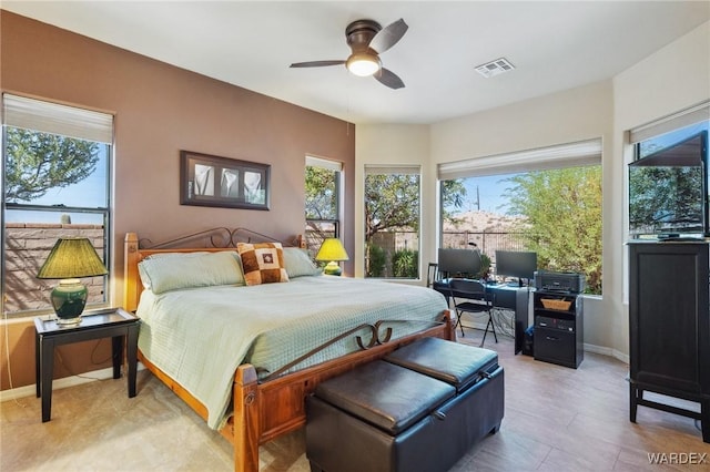 bedroom with baseboards, multiple windows, visible vents, and a ceiling fan