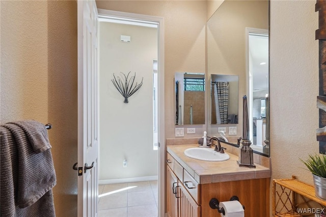 bathroom featuring tile patterned flooring, vanity, and baseboards