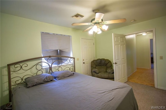 bedroom with light carpet, baseboards, visible vents, and a ceiling fan