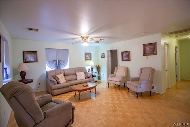 living area featuring ceiling fan and visible vents
