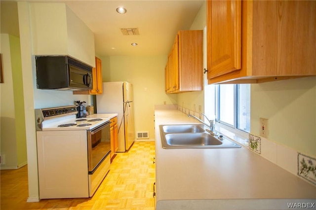 kitchen with white appliances, light countertops, and visible vents