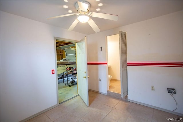 spare room with ceiling fan and light tile patterned flooring