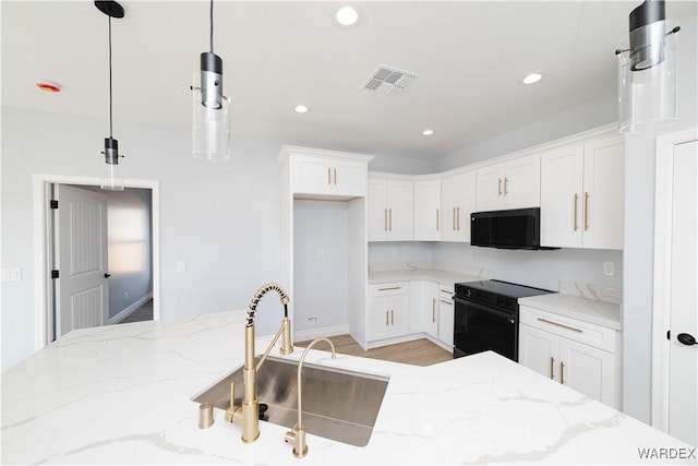 kitchen with visible vents, pendant lighting, white cabinetry, and electric range