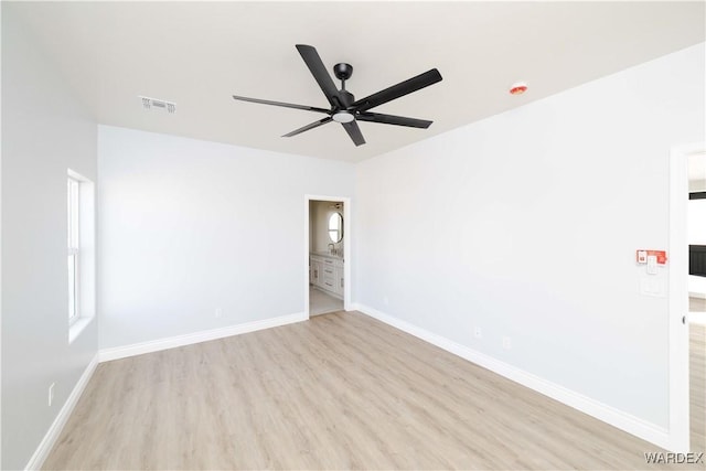 empty room featuring light wood-style floors, baseboards, and visible vents