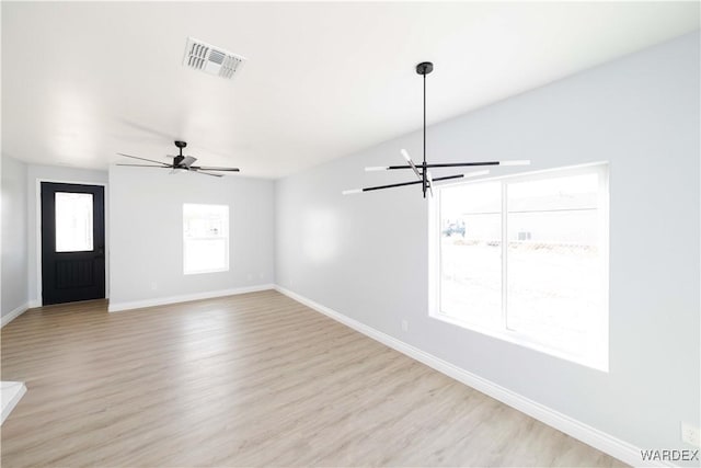 interior space with light wood-type flooring, baseboards, visible vents, and ceiling fan with notable chandelier