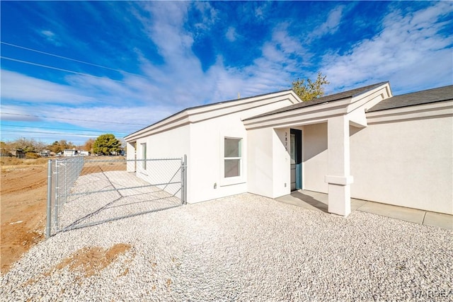 exterior space featuring a patio area, fence, and stucco siding