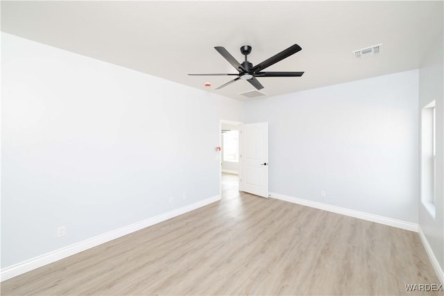 unfurnished room featuring a ceiling fan, light wood-type flooring, visible vents, and baseboards