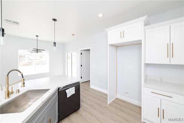 kitchen with hanging light fixtures, black dishwasher, white cabinets, and a sink