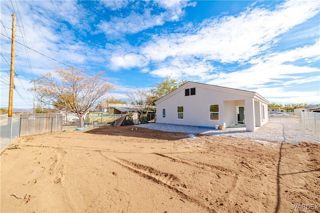 rear view of property with a fenced backyard and stucco siding