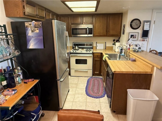 441 Moser Ave Unit B3, Bullhead City, AZ 86429 - kitchen with stainless steel appliances, a sink, light tile patterned flooring, a peninsula, and butcher block countertops