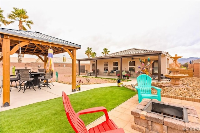 view of patio with outdoor dining space, a gazebo, and fence