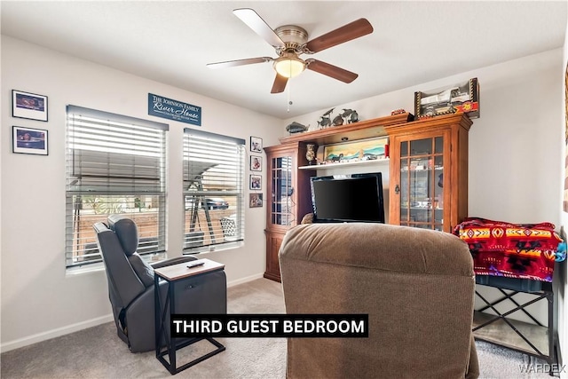 living room featuring ceiling fan, baseboards, and carpet