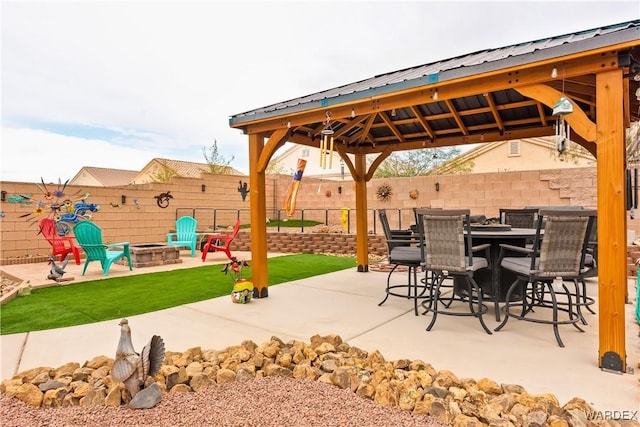 view of patio featuring a gazebo, outdoor dining area, a fire pit, and a fenced backyard