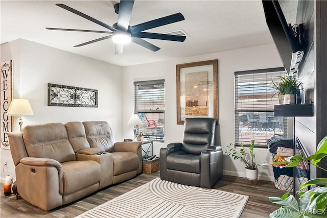 living room featuring visible vents, baseboards, ceiling fan, and wood finished floors