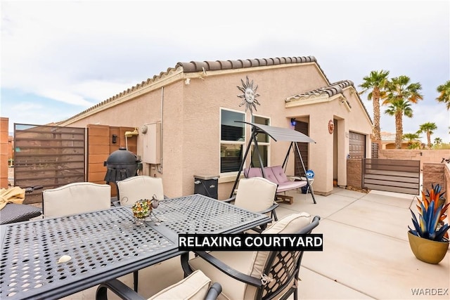 view of patio featuring outdoor dining space, fence, and a grill