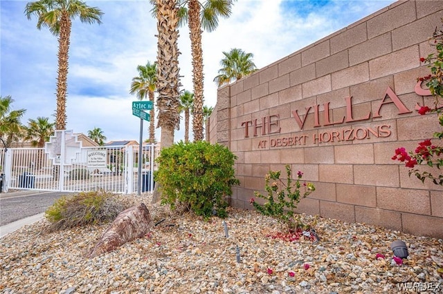 community sign featuring a gate and fence