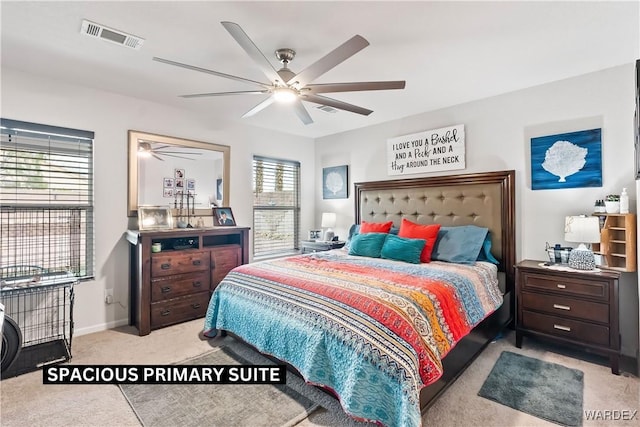 carpeted bedroom with visible vents, baseboards, and a ceiling fan