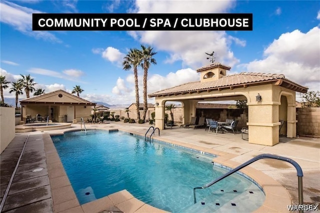 community pool with a patio and fence